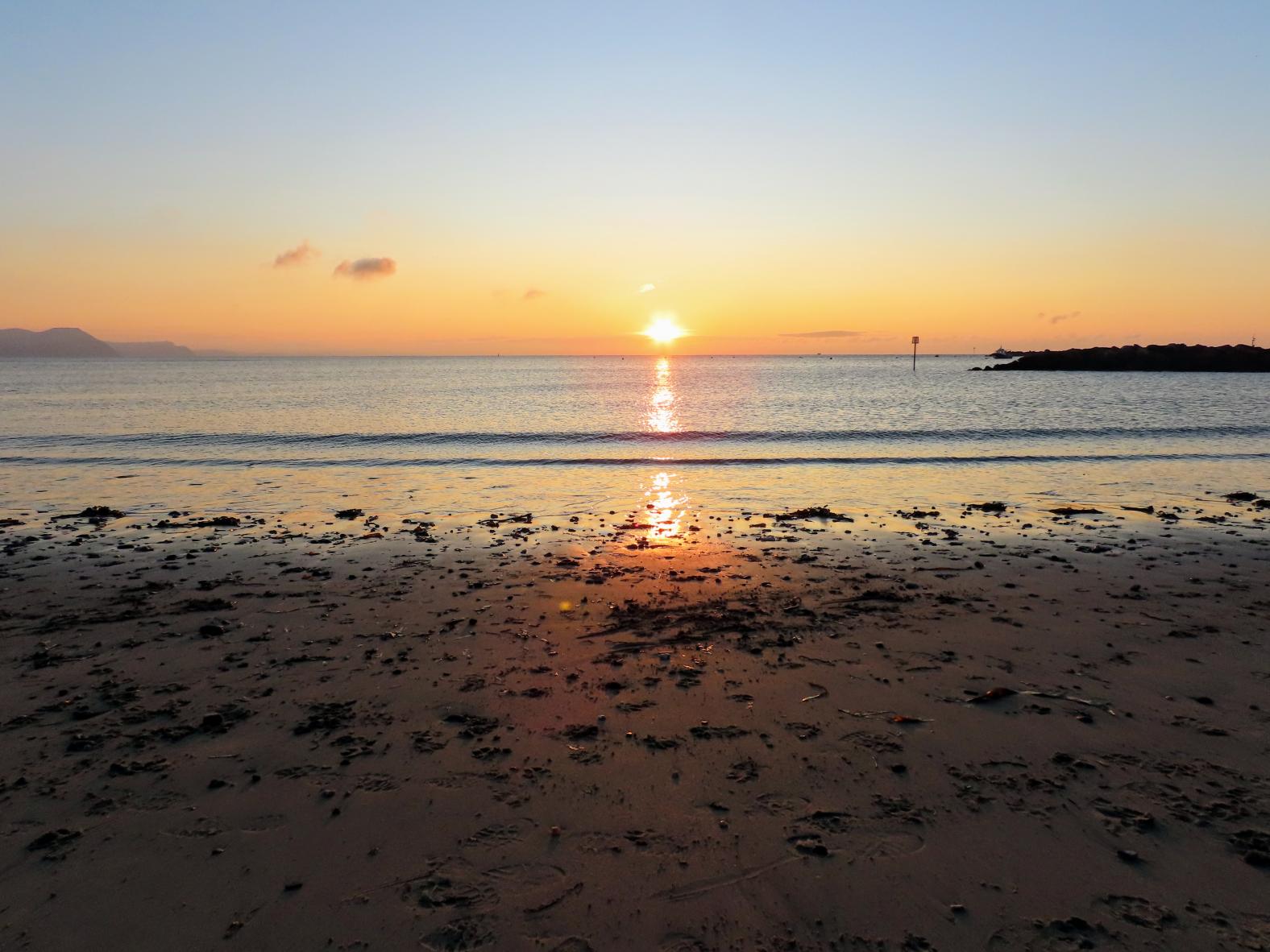Sunrise from sandy beach Lyme Regis